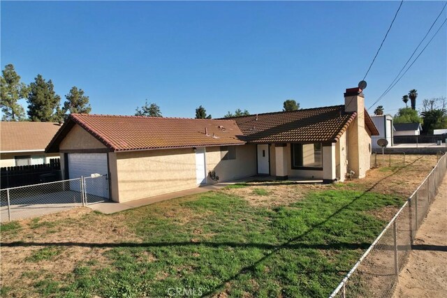 ranch-style home featuring a garage and a front lawn