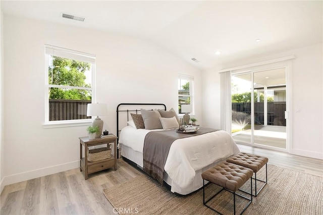 bedroom with light wood-type flooring, vaulted ceiling, and access to outside