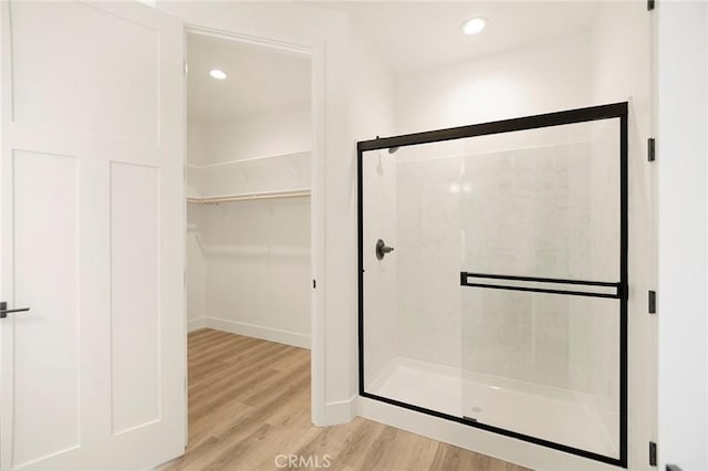 bathroom with hardwood / wood-style flooring and walk in shower