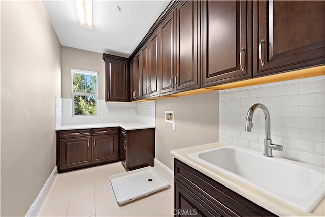 laundry area with washer hookup, cabinets, light tile patterned floors, and sink