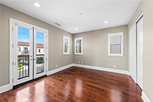 interior space featuring access to outside, a closet, dark hardwood / wood-style flooring, and french doors