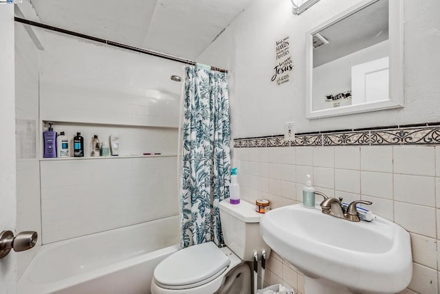 full bathroom featuring toilet, tile walls, sink, and shower / bath combination with curtain