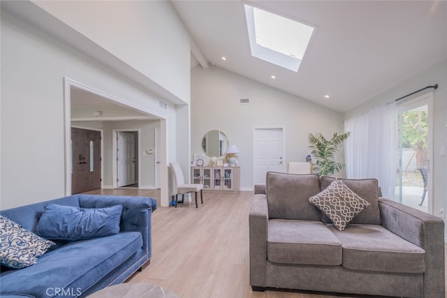 living room featuring a skylight, hardwood / wood-style flooring, and high vaulted ceiling