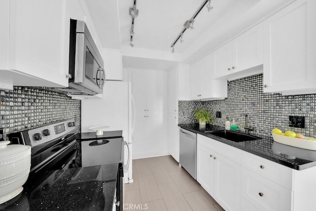 kitchen featuring backsplash, sink, stainless steel appliances, and white cabinetry