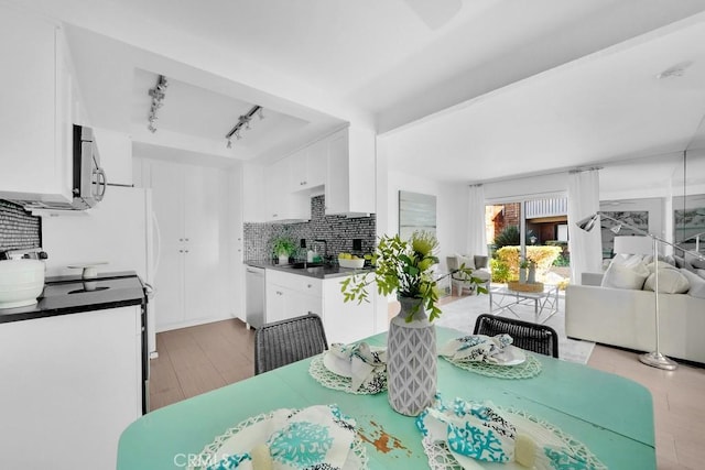 dining area with sink and rail lighting