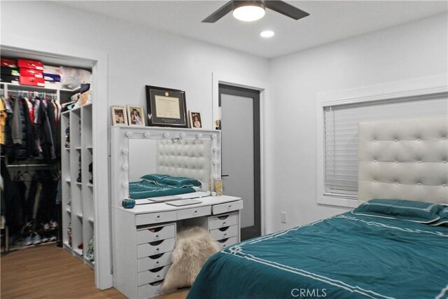 bedroom with ceiling fan, light hardwood / wood-style floors, and a closet