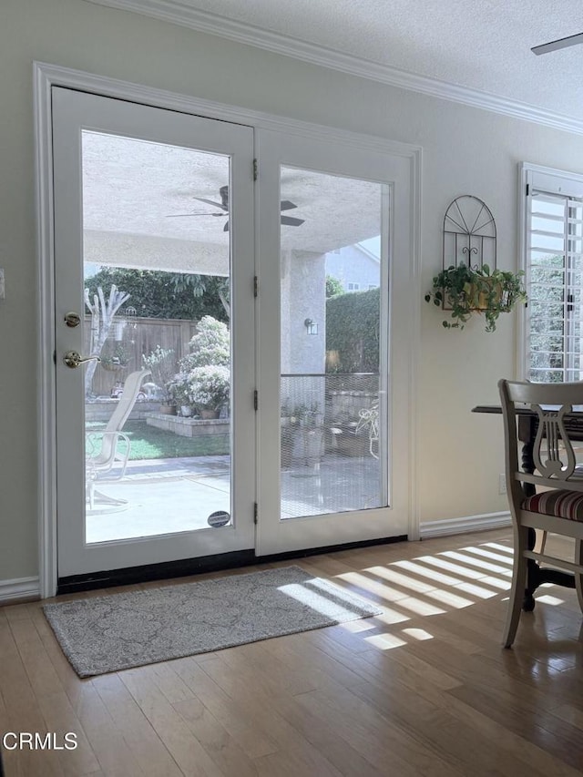 entryway featuring a textured ceiling, ornamental molding, and hardwood / wood-style floors