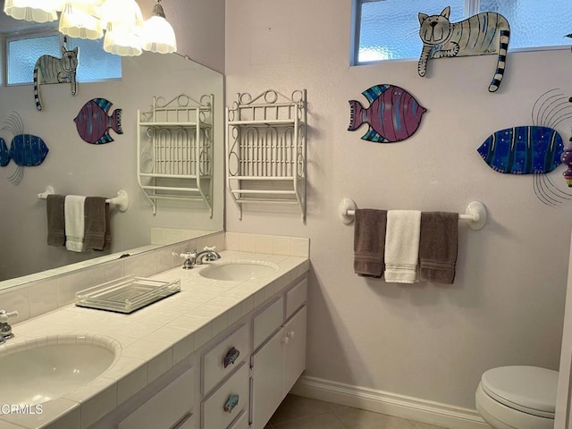 bathroom with toilet, vanity, and tile patterned flooring