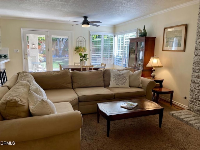 living room with a textured ceiling, ceiling fan, a wealth of natural light, and carpet