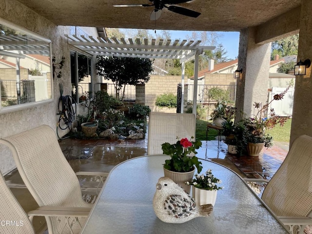 view of patio with outdoor dining area, fence, a ceiling fan, and a pergola