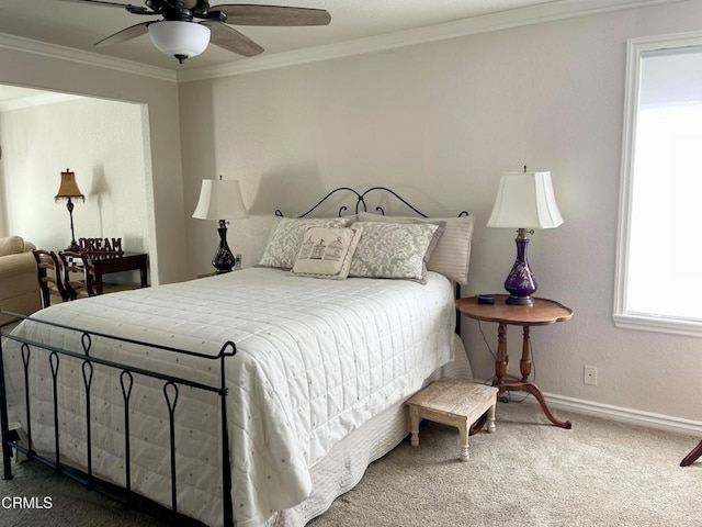 carpeted bedroom featuring ceiling fan, baseboards, and ornamental molding