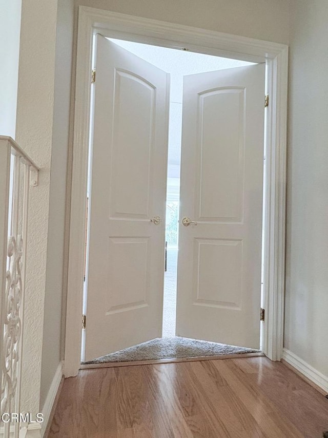 hallway featuring baseboards and wood finished floors