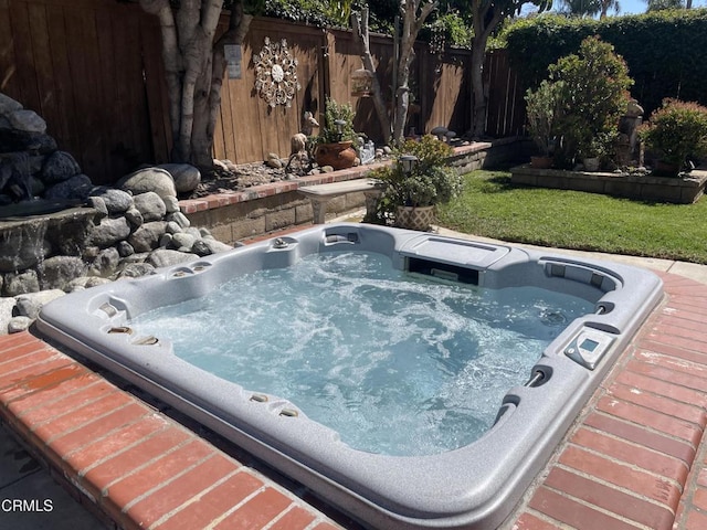 view of swimming pool with an outdoor hot tub and fence