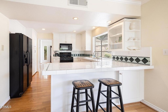 1590 Frazier St, Camarillo, CA 93012 - kitchen with black appliances, a peninsula, backsplash, light wood finished floors, and ornamental molding