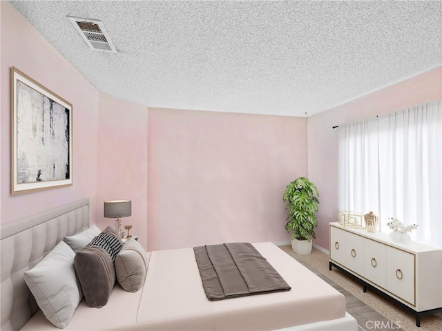 carpeted bedroom featuring a textured ceiling