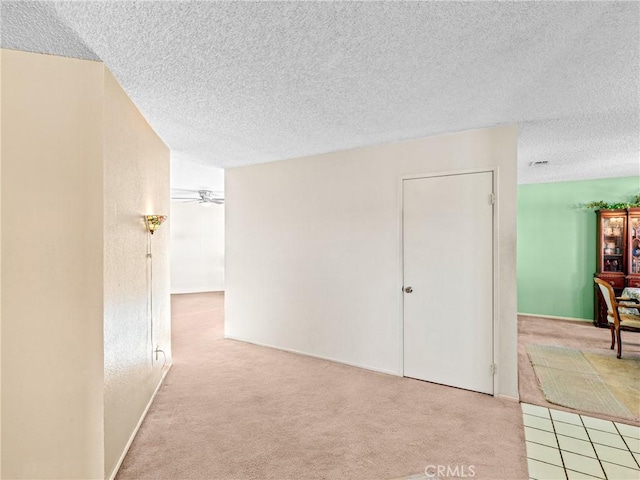 interior space featuring light colored carpet and a textured ceiling