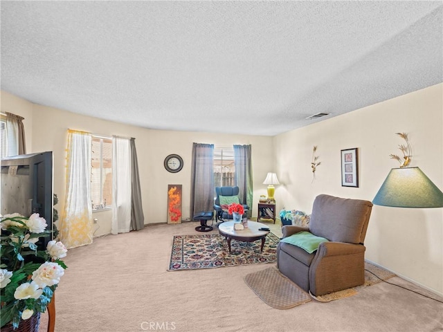 living room with plenty of natural light, light carpet, and a textured ceiling