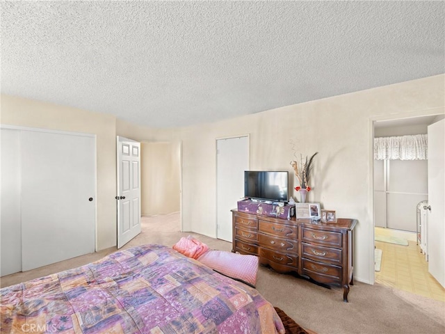 carpeted bedroom featuring a textured ceiling and a closet