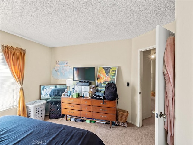 bedroom featuring light carpet and a textured ceiling