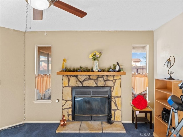 carpeted living room featuring a fireplace and ceiling fan