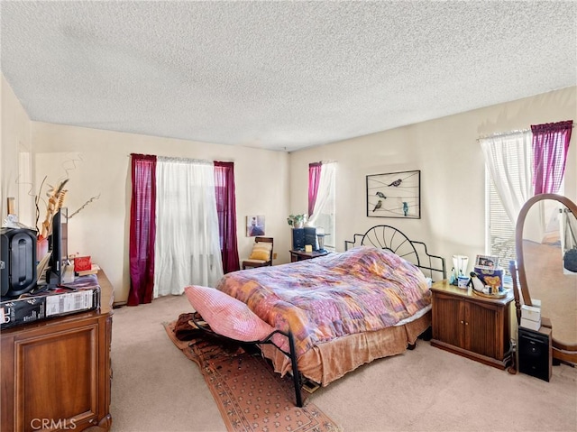 bedroom featuring light colored carpet and a textured ceiling