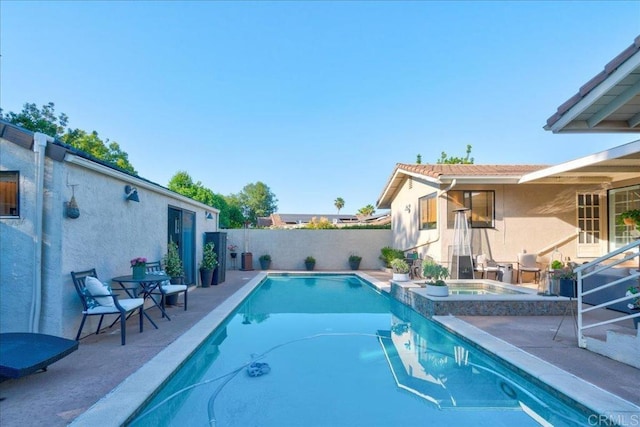 view of swimming pool with an in ground hot tub and a patio