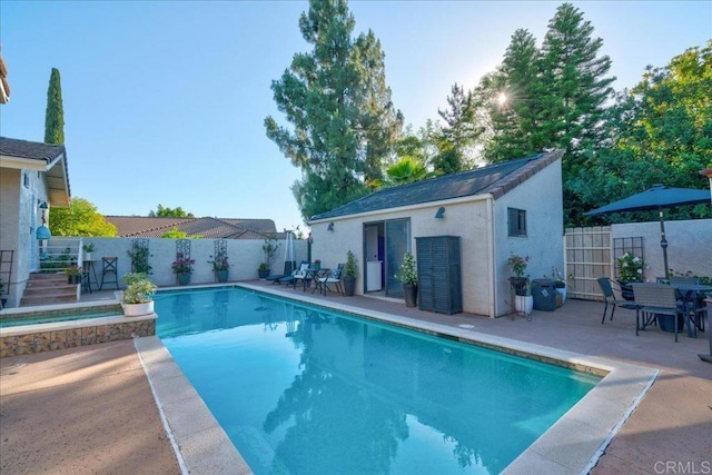 view of swimming pool with an outdoor structure and a patio