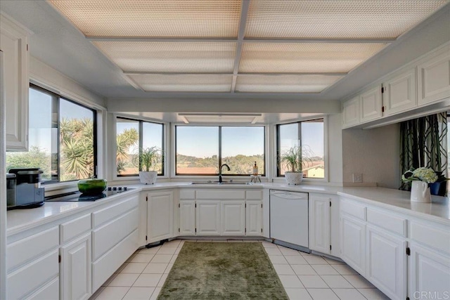 kitchen featuring sink, white dishwasher, black electric stovetop, white cabinets, and light tile patterned flooring