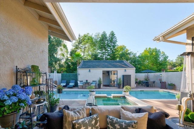 view of pool featuring an outdoor hangout area, a patio area, an outdoor structure, and an in ground hot tub