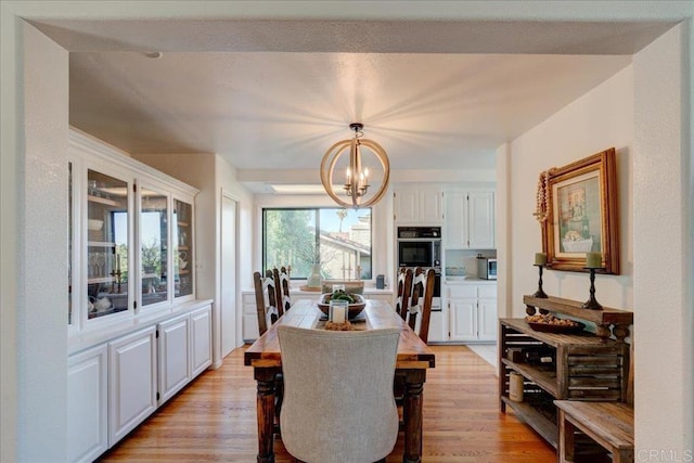 dining area featuring an inviting chandelier and light hardwood / wood-style flooring