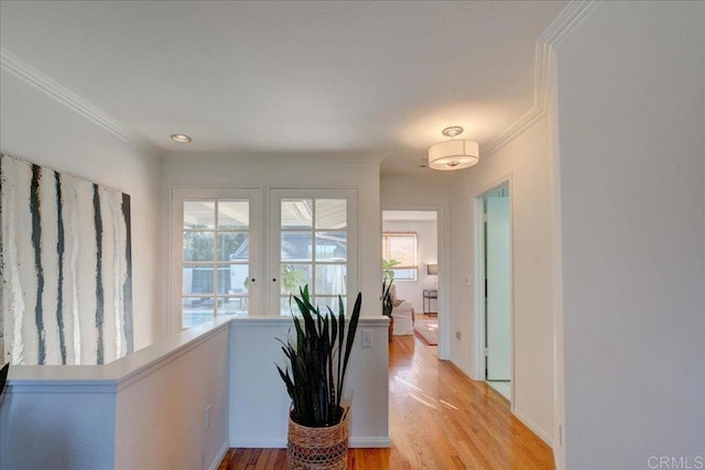 hallway with ornamental molding and light hardwood / wood-style floors