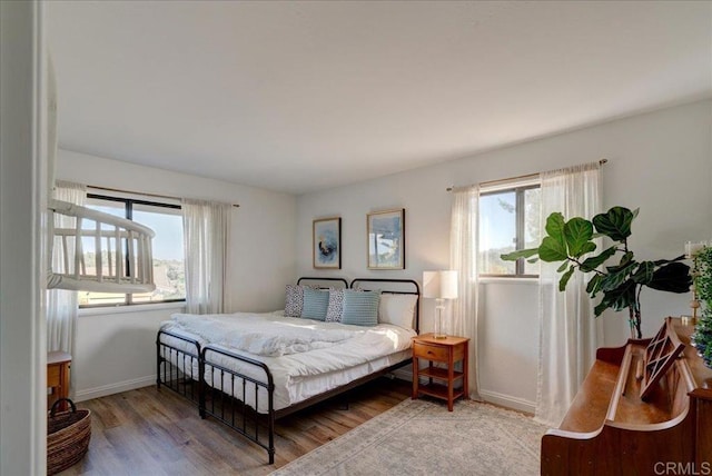 bedroom with hardwood / wood-style flooring and multiple windows