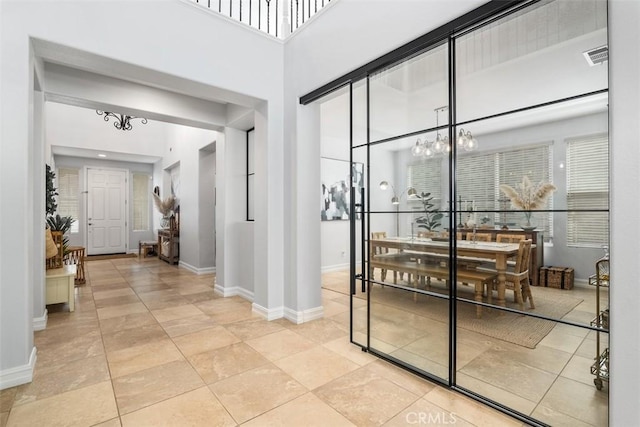 wine area with a high ceiling, light tile patterned floors, and an inviting chandelier