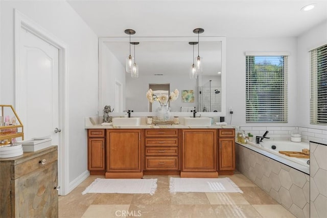 bathroom featuring tiled tub, vanity, and tile patterned flooring