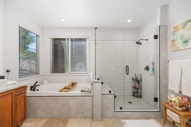 bathroom with plus walk in shower, tile patterned floors, and vanity