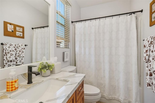 bathroom featuring toilet, vanity, and a shower with shower curtain