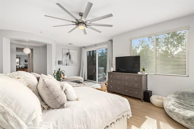 bedroom with ceiling fan, access to outside, multiple windows, and light hardwood / wood-style flooring