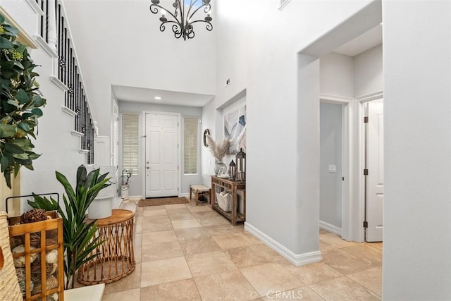 tiled entryway with a towering ceiling and an inviting chandelier