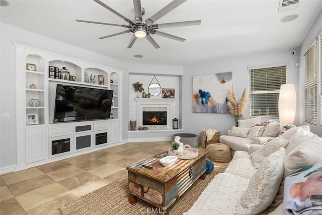 living room featuring ceiling fan and built in features