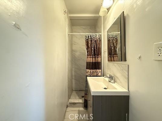 bathroom with vanity, tile patterned flooring, and walk in shower