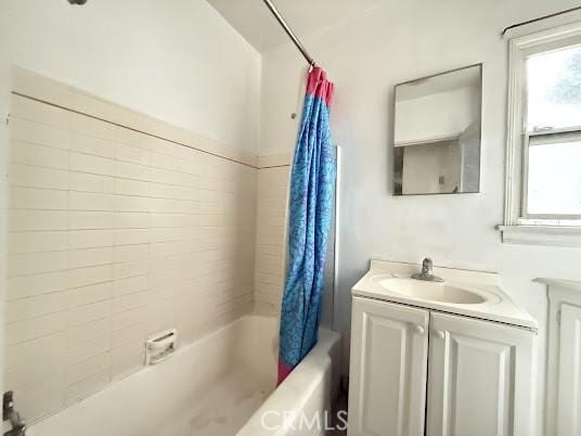 bathroom featuring shower / bath combination with curtain and vanity