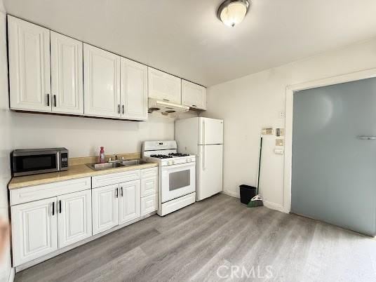 kitchen with light wood-type flooring, sink, white cabinets, and white appliances