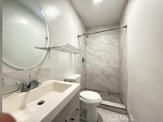 bathroom featuring curtained shower, tile patterned floors, toilet, and vanity