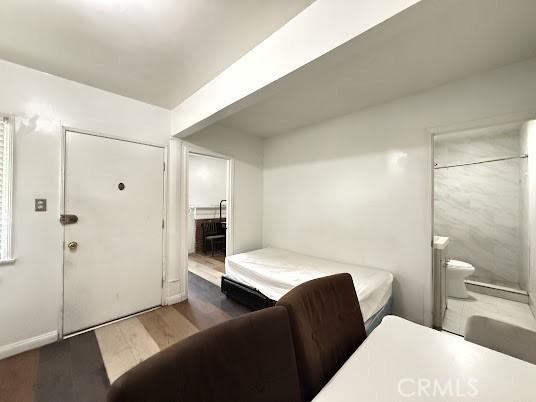 bedroom with dark wood-type flooring and ensuite bath