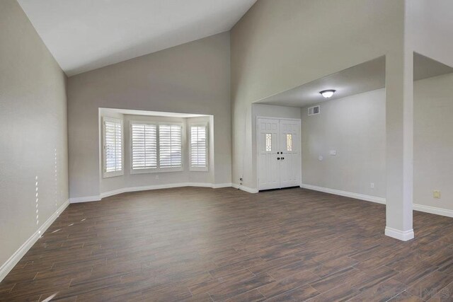 foyer entrance featuring dark hardwood / wood-style flooring and high vaulted ceiling