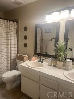 bathroom with a shower with curtain, vanity, and toilet