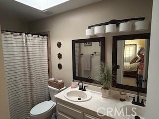 bathroom with vanity, a skylight, toilet, and a shower with shower curtain