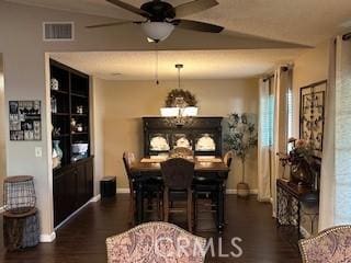 dining space with dark wood-type flooring and ceiling fan with notable chandelier