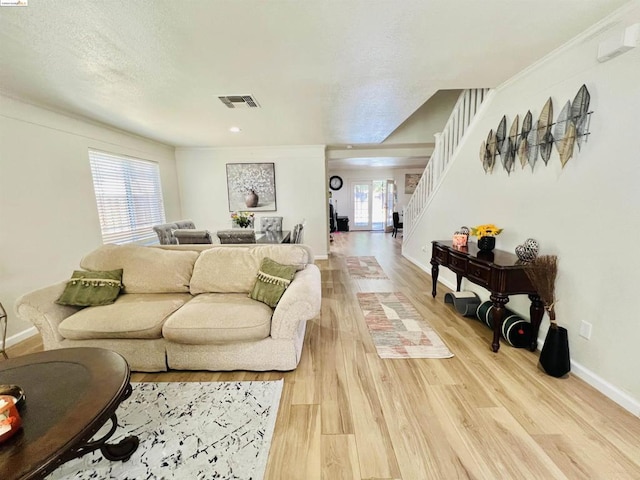 living room with plenty of natural light, wood-type flooring, and a textured ceiling