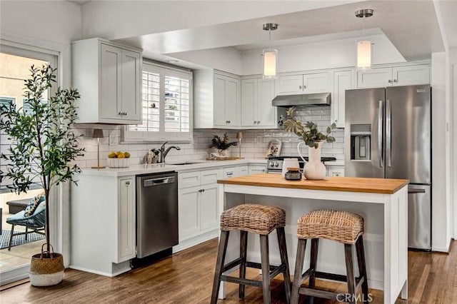 kitchen featuring a center island, stainless steel appliances, white cabinetry, and sink